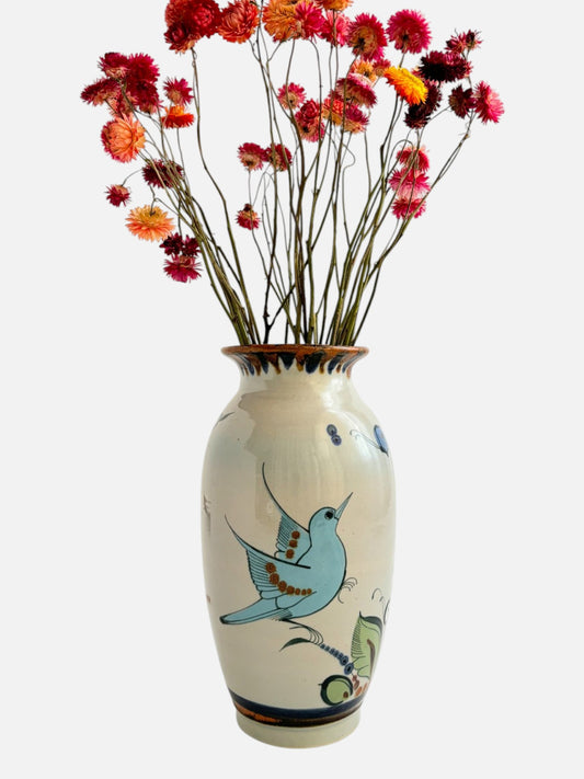 Vintage Ken Edwards Tonala hand-painted and signed tall ceramic vase handmade in Mexico featuring bird and floral design shown from the front view with flowers displayed