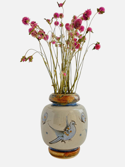 Vintage Ken Edwards Tonala hand-painted and signed round ceramic vase handmade in Mexico featuring bird and floral design shown from the front view with flowers displayed