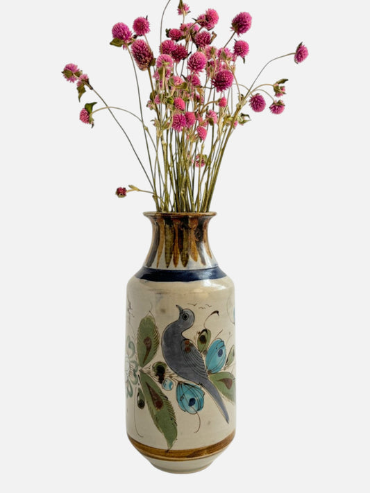 Vintage Ken Edwards Tonala hand-painted and signed tall ceramic vase handmade in Mexico featuring bird and floral design shown from the front view with flowers displayed